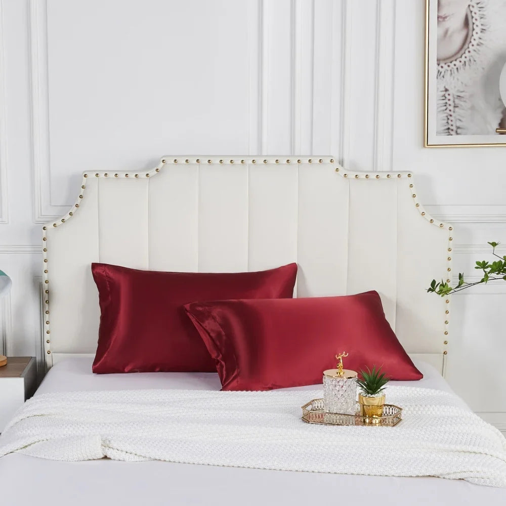 Deux taies d'oreiller satinées rouges sur un lit